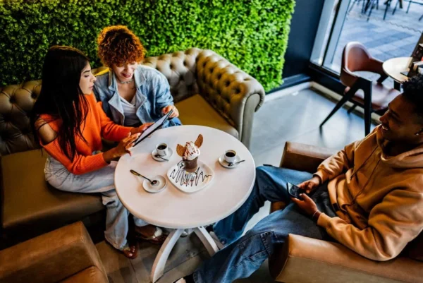 Creative team collaborating at a cafe for brand growth strategies.